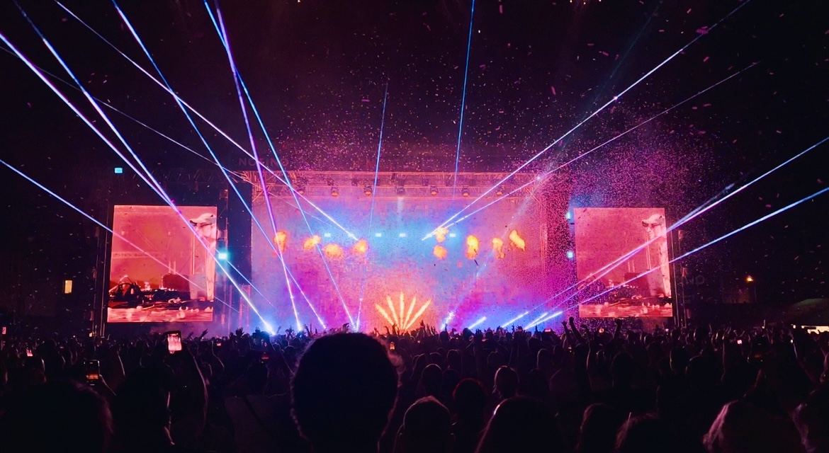 Arena festival stage with stadium laser beams, pyro, and confetti