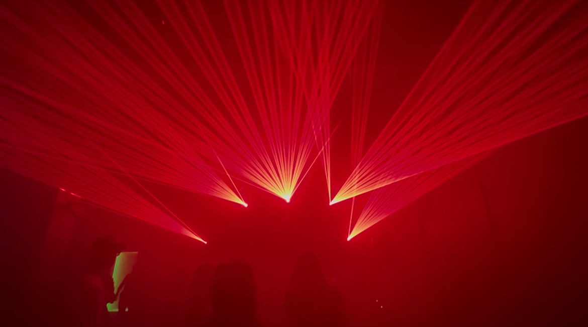 Crimson red fan laser projection array spanning across venue